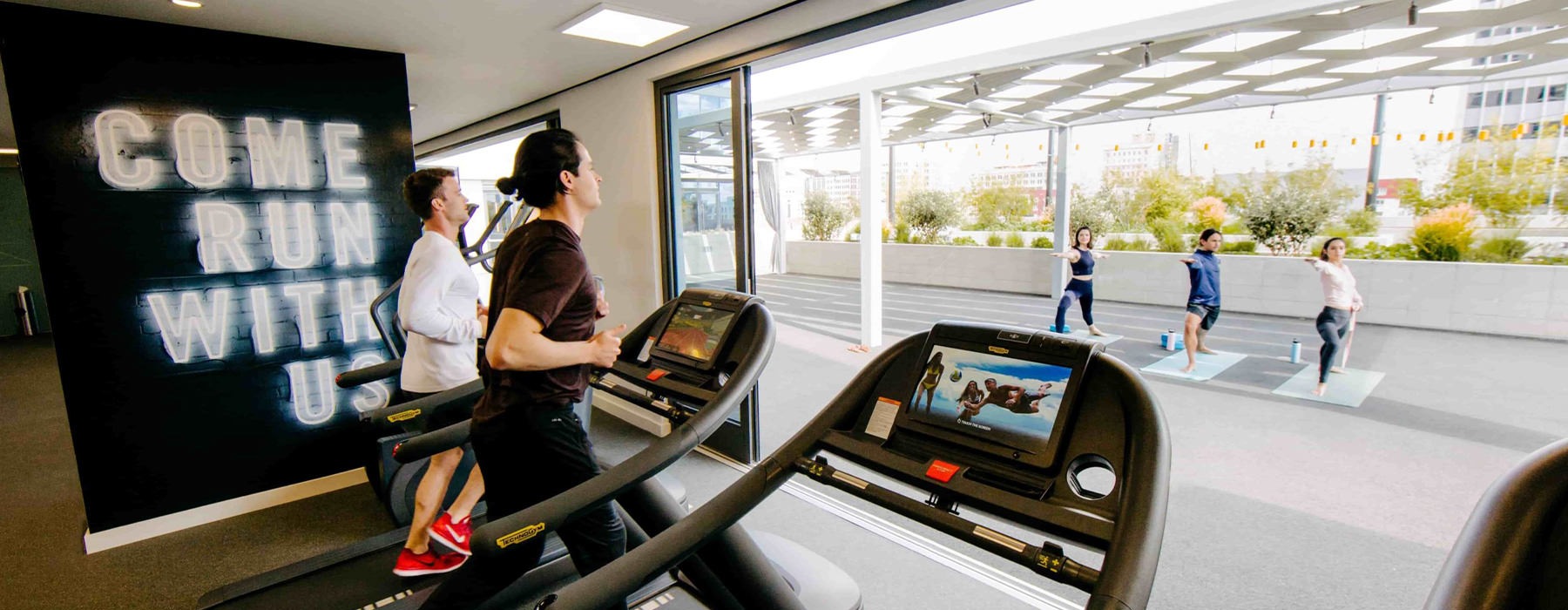 lifestyle image of people running on treadmills