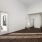 Spacious and well lit living room with wood flooring, large windows and open access to the kitchen